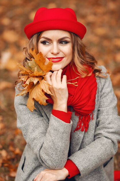 Belle femme assise dans un parc en automne