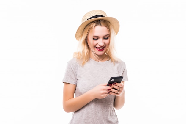 Belle femme au chapeau lumineux à l'aide d'un nouveau téléphone mobile