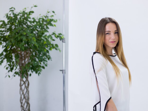 Belle femme aux cheveux bruns en robe blanche