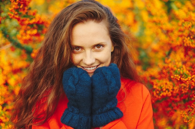 Photo gratuite belle femme aux longs cheveux ondulés touchant le menton avec de la laine douce