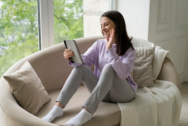 Belle femme ayant un appel vidéo à la maison