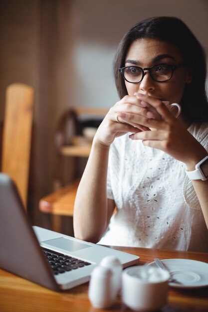 Belle femme ayant une tasse de café au café