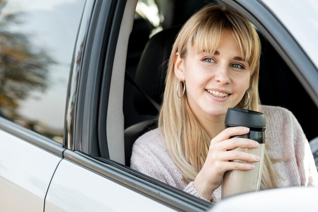 Belle femme blonde assise dans la voiture