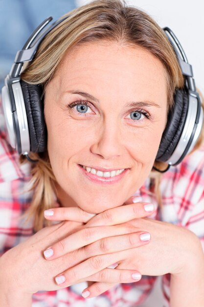 Photo gratuite belle femme blonde écoute de la musique avec des écouteurs