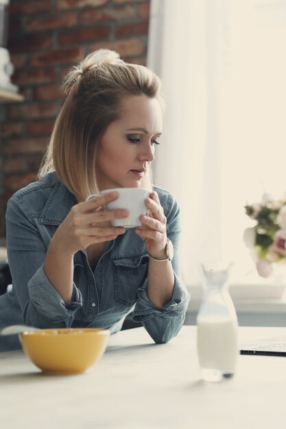 Belle femme blonde à la maison