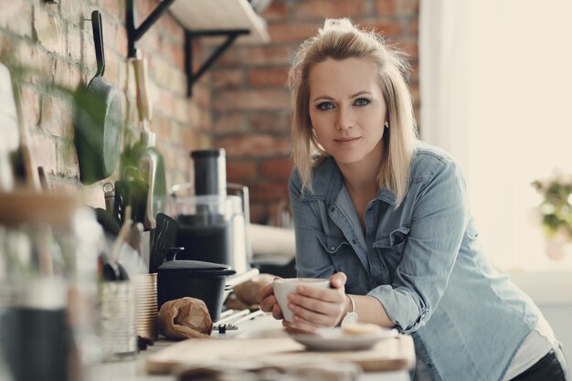 Belle femme blonde à la maison