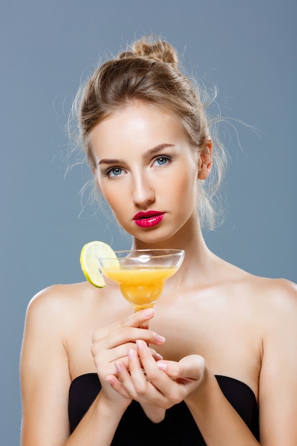 Belle femme blonde tenant un cocktail