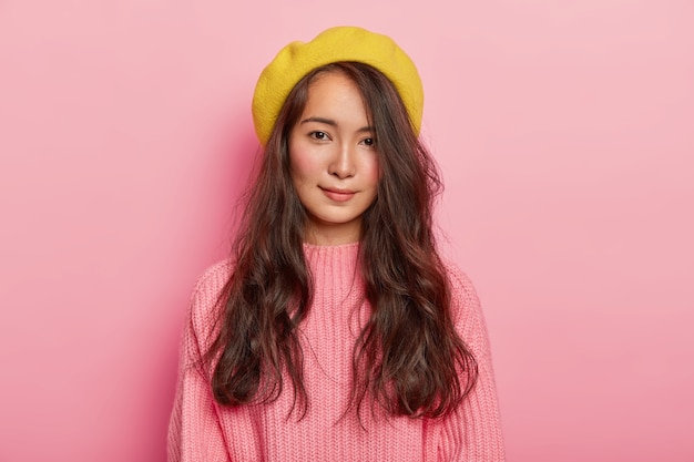 Photo gratuite belle femme brune d'apparence métisse, porte un béret jaune et un pull rose