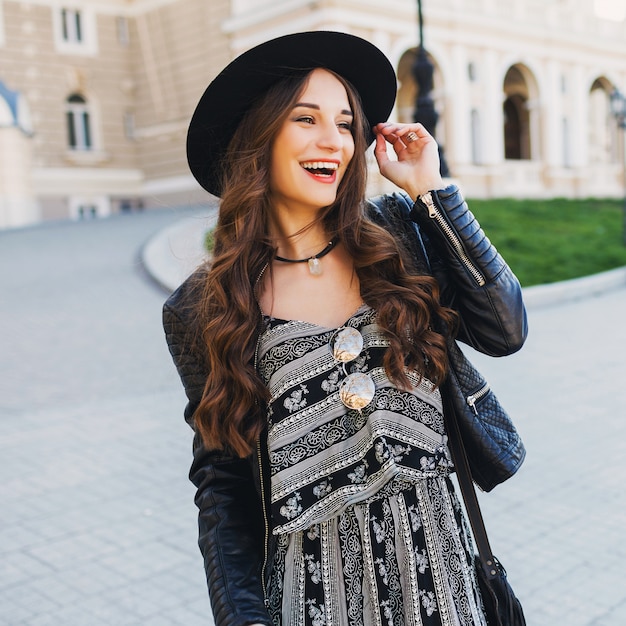 Belle Femme Brune Incroyable Avec Une Longue Coiffure Ondulée Au Printemps Ou à L'automne Tenue Urbaine élégante Marchant Dans La Rue. Lèvres Rouges, Corps Mince. Concept De Mode De Rue.