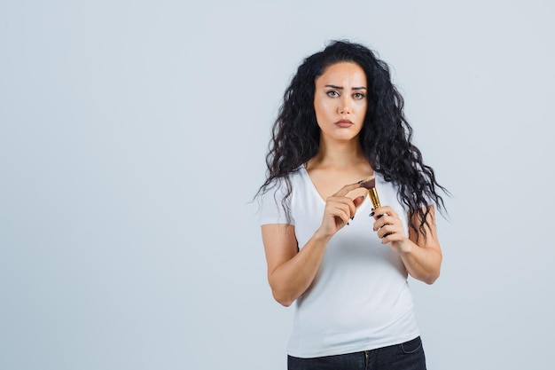 Belle femme brune avec un pinceau de maquillage