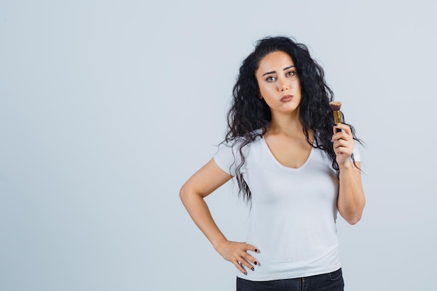 Belle femme brune avec un pinceau de maquillage