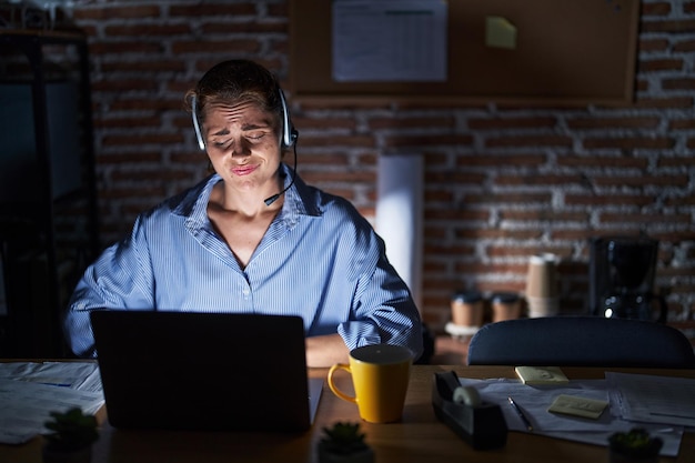 Photo gratuite belle femme brune travaillant au bureau la nuit avec la main sur le ventre parce que l'indigestion maladie douloureuse se sent mal concept de douleur