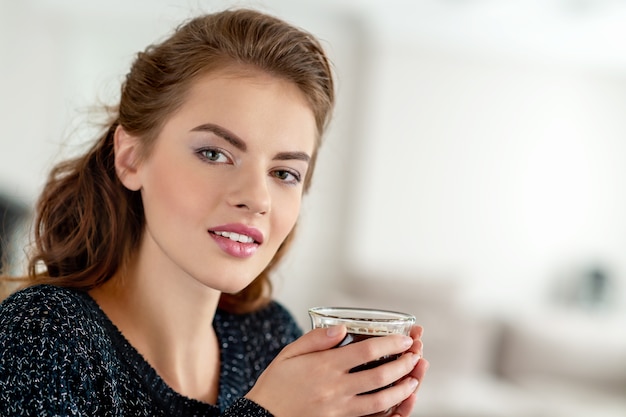 Belle femme buvant du café le matin à la maison