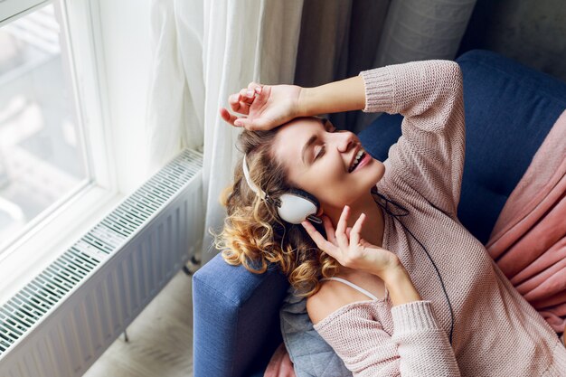 Belle femme sur le canapé, écouter de la musique