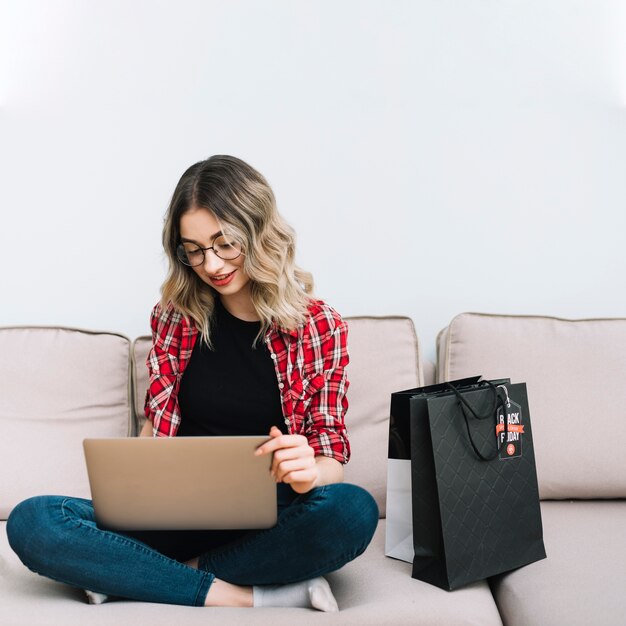 Belle femme sur un canapé, shopping en ligne