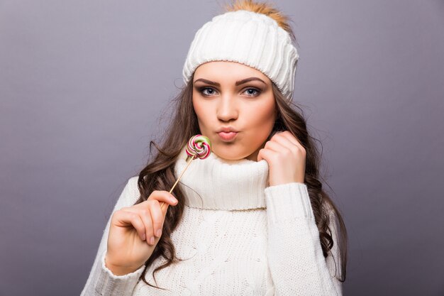 Belle femme avec chapeau blanc tenant sucette