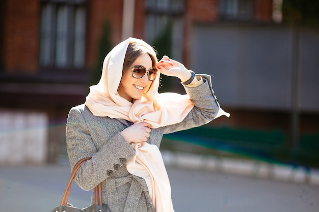 Belle femme dans un manteau posant dans la rue