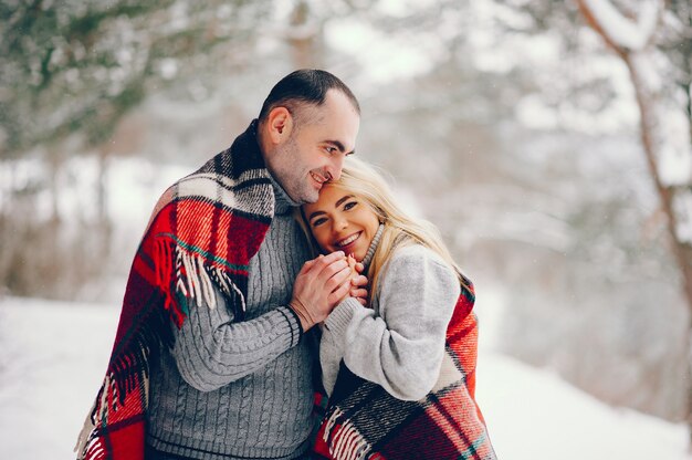 Belle femme dans un parc d'hiver avec son mari