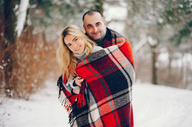 Belle femme dans un parc d'hiver avec son mari