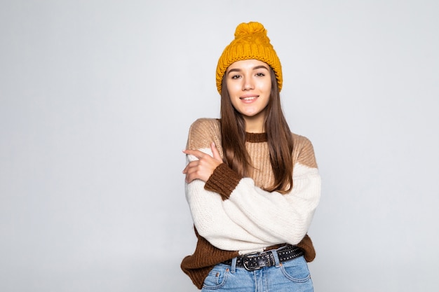 Belle femme dans des vêtements chauds isolé sur mur blanc