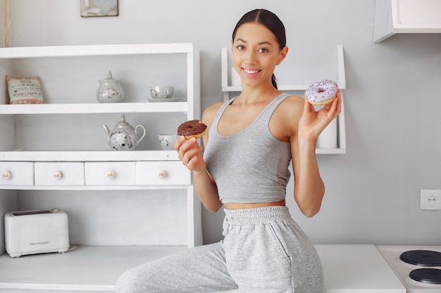 Belle Femme Debout Dans Une Cuisine Avec Beignet