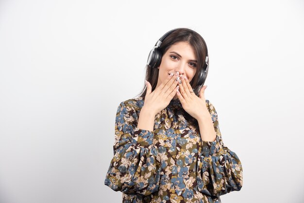 Belle Femme écoutant La Chanson Et Fermant Sa Bouche Sur Fond Blanc.