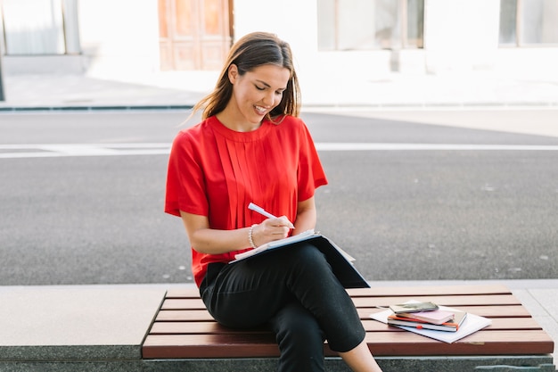 Belle femme écrivant une note dans le journal