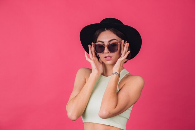 Belle femme élégante en chapeau et lunettes de soleil posant