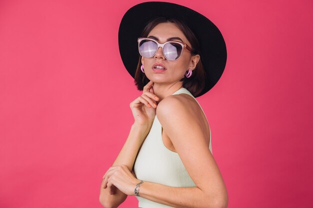 Belle femme élégante en chapeau et lunettes de soleil posant