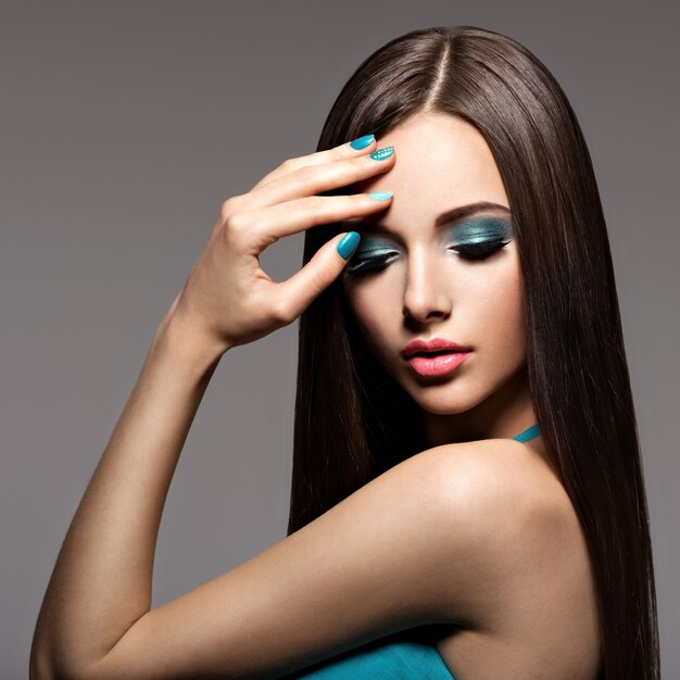 Belle femme élégante avec maquillage turquoise et ongles - pose