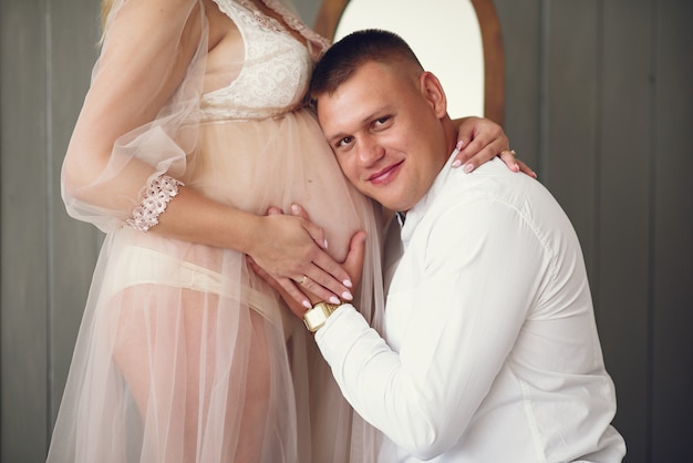 Belle femme enceinte avec son mari dans un studio