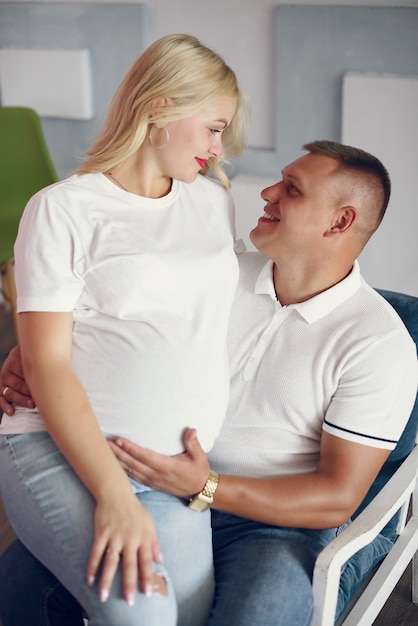 Belle femme enceinte avec son mari dans un studio