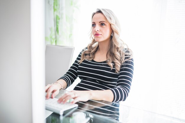 Belle femme enceinte travaillant dans le bureau