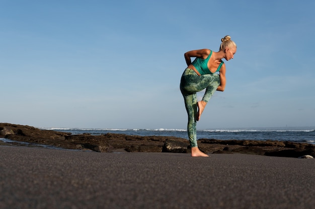 Photo gratuite belle femme faisant du yoga sur la plage