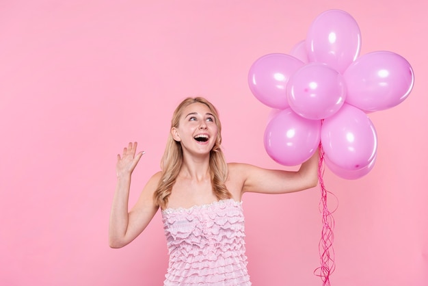 Photo gratuite belle femme à la fête en tenant des ballons