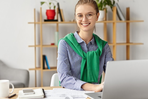 Belle femme habillée officiellement au bureau avec ordinateur portable