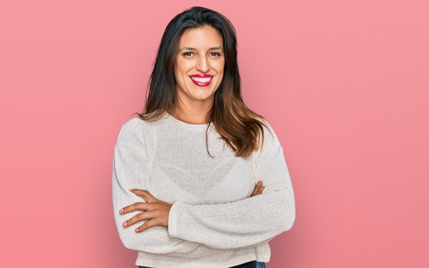 Belle femme hispanique portant un chandail décontracté visage heureux souriant avec les bras croisés regardant la personne positive de la caméra