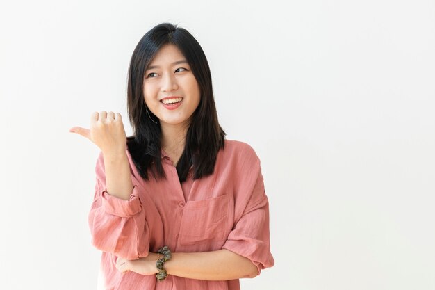 Belle femme joyeuse debout près d'un mur blanc