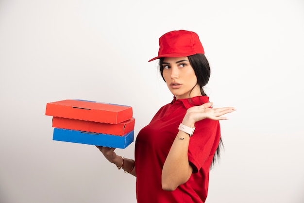 Belle femme de livraison tenant un tas de boîtes à pizza.
