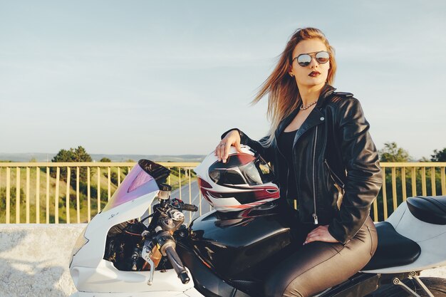 Belle femme, à, lunettes soleil, conduite, sur, moto