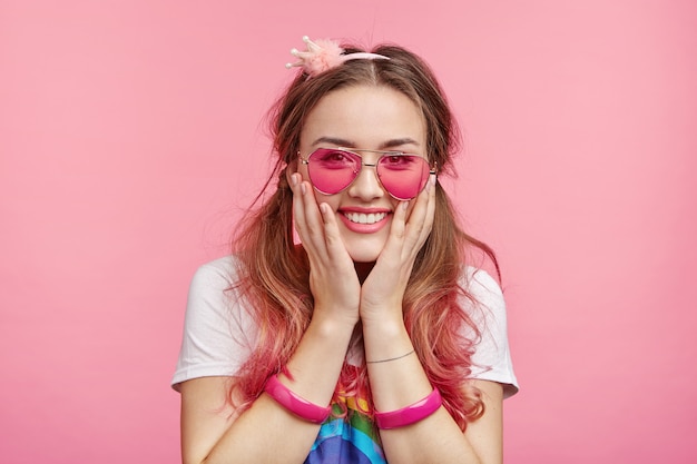 Belle femme avec des lunettes de soleil roses à la mode