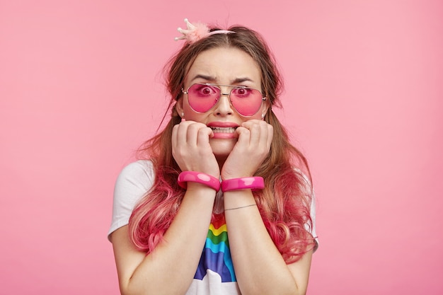 Belle femme avec des lunettes de soleil roses à la mode