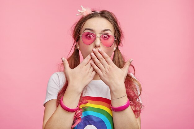 Belle femme avec des lunettes de soleil roses à la mode