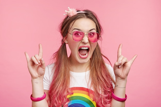 Belle femme avec des lunettes de soleil roses à la mode