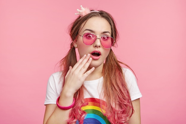 Belle femme avec des lunettes de soleil roses à la mode