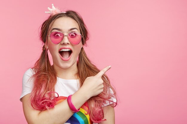 Belle femme avec des lunettes de soleil roses à la mode