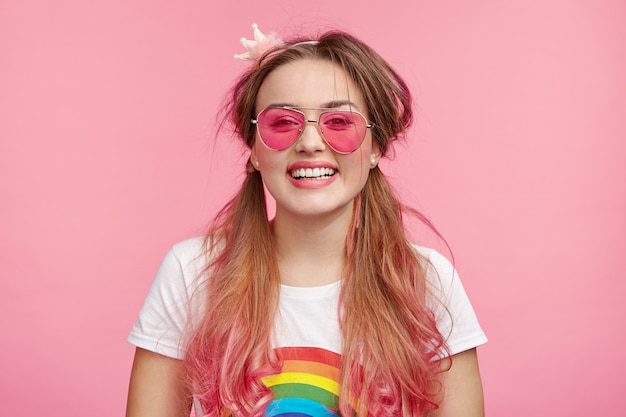 Belle femme avec des lunettes de soleil roses à la mode