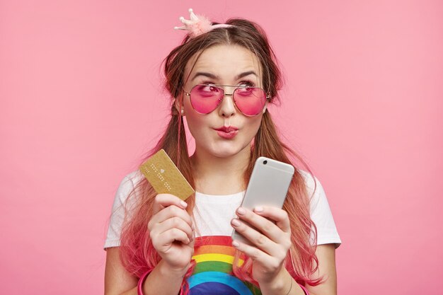 Belle femme avec des lunettes de soleil roses à la mode