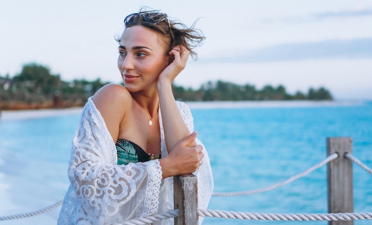 Photo gratuit belle femme en maillot de bain au bord de l'océan