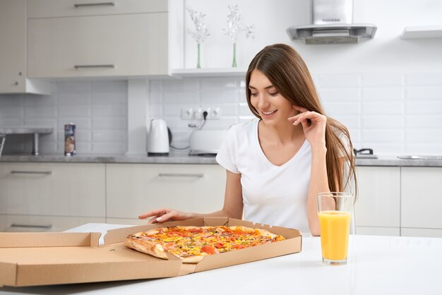 Belle femme mangeant de délicieuses pizzas